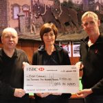 Carole from iSightCornwall along with two staff members from the 'Bird in Hand' pub holding a large cheque for £1500.