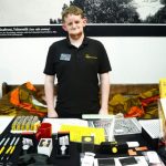 Dom Hall demonstrating the items available in our shop at The Poly in Falmouth