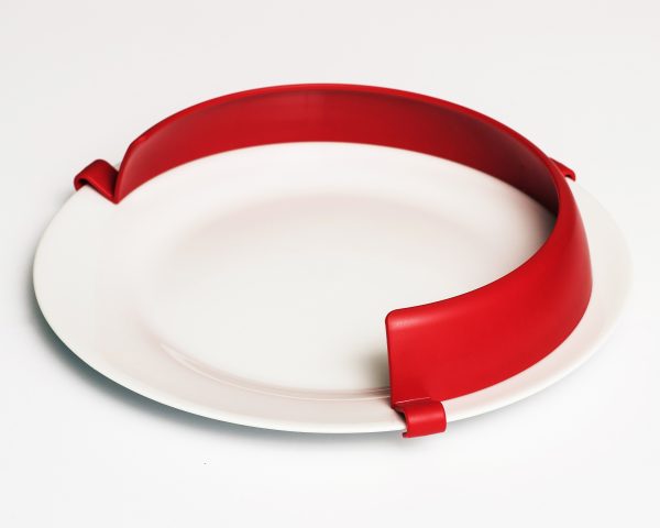 A bright red plate guard attached to a white plate.