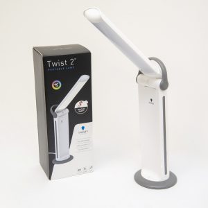 A white light with a base and a folding hinge stands next to a box which reads Twist 2